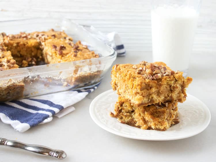 slices of pumpkin dump cake next to the baking dish