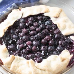 blueberry tart on counter with blue and white towel in the background