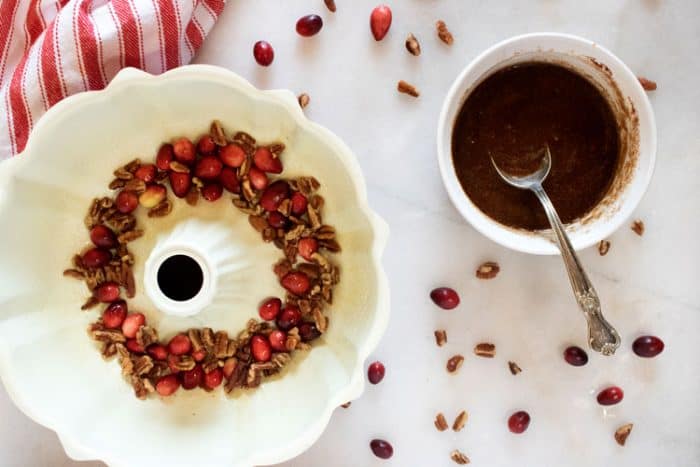 layering cranberries and pecans in the bundt cake pan