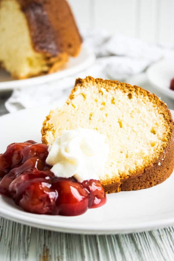 slice of cream cheese pound cake with berries and whipped cream