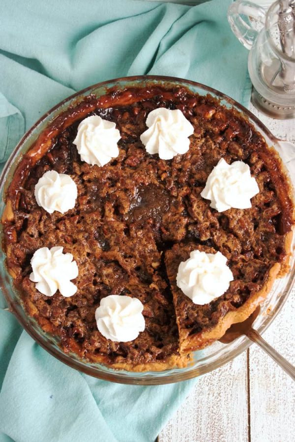 full derby pie with overhead shot. whipped cream dollops on top.