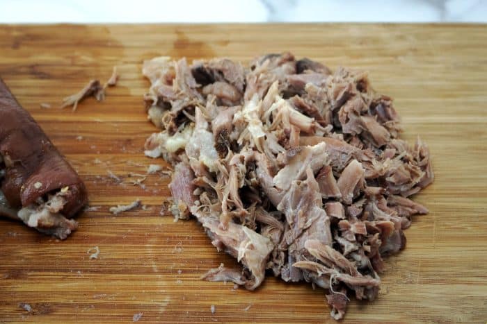 chopped up cooked pork on cutting board