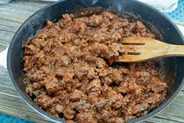 ground beef with pizza sauce mixed in in pan