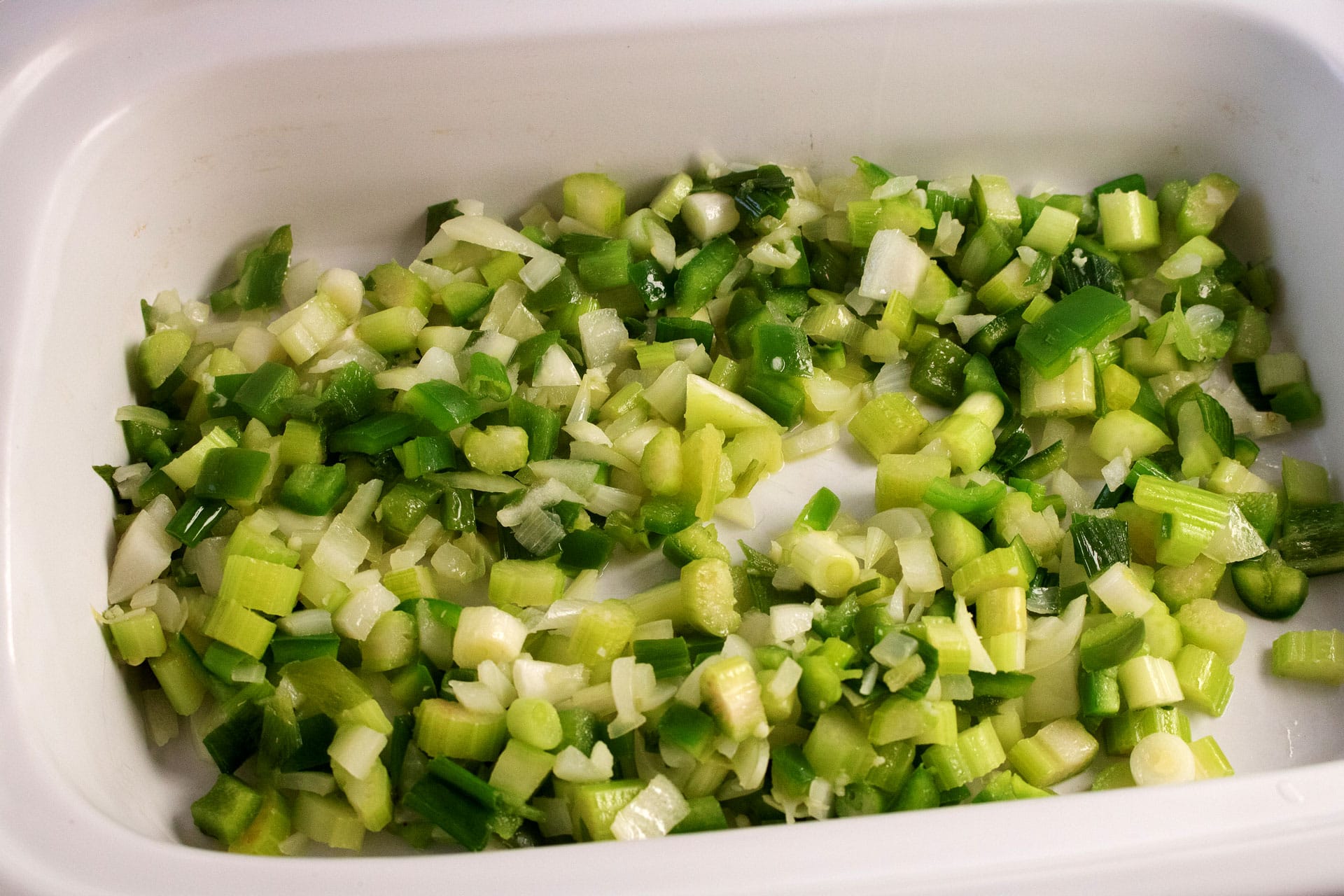 Diced celery, green bell pepper, onion and scallions in a slow cooker