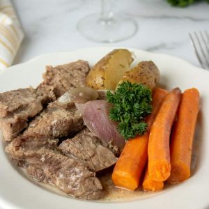 slow cooker pot roast on white plate with carrots