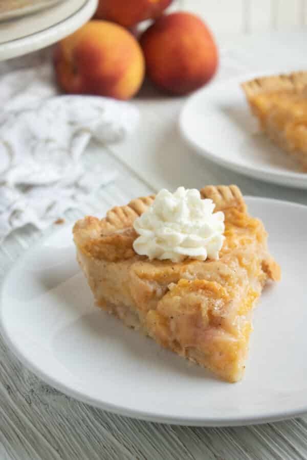 slice of peach pie on a white plate