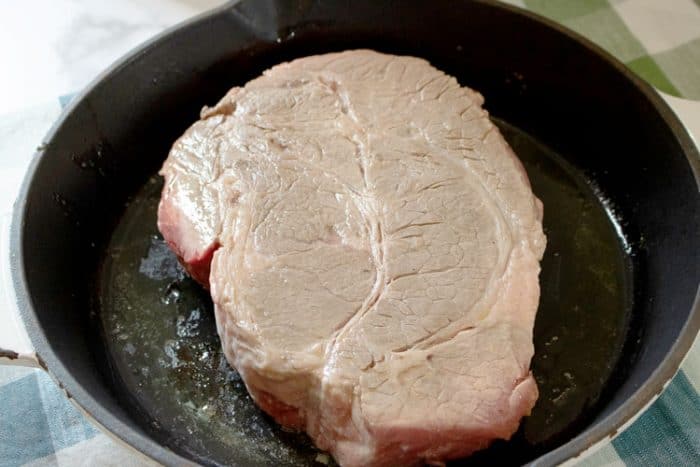 browning a roast beef in a cast iron pan