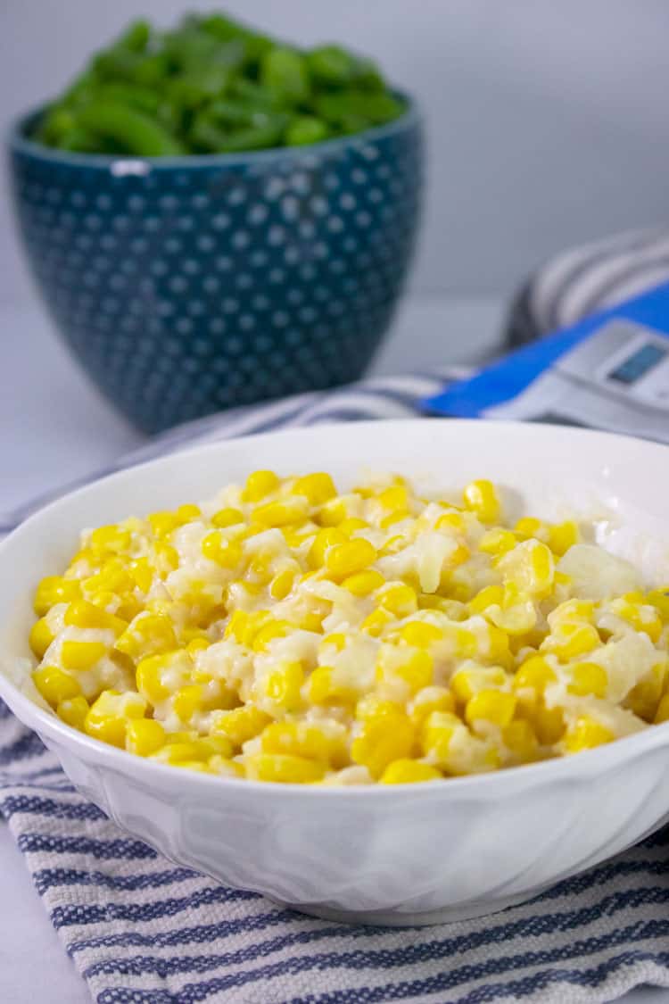 creamed corn being served in a white bowl