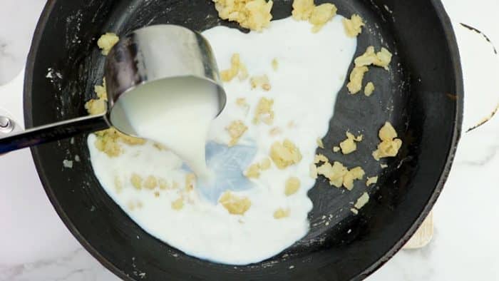 adding milk to the creamed corn