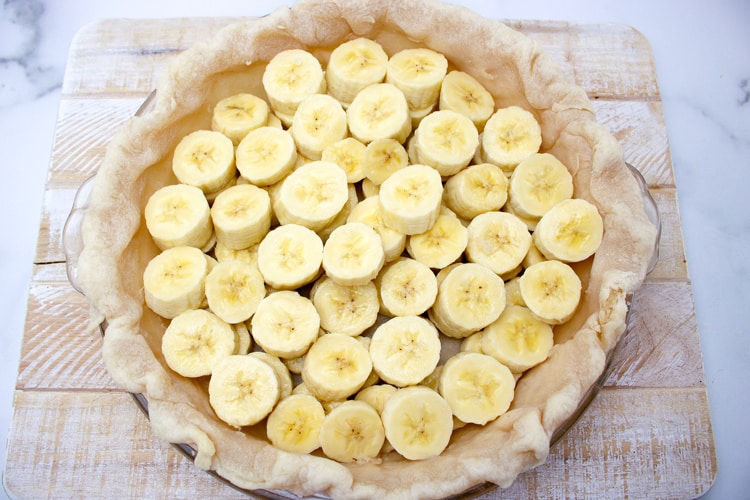 banana slices filling a partially baked pie crust