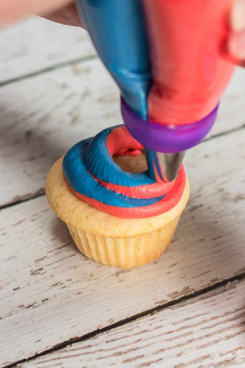 adding frosting to red white and blue cupcakes