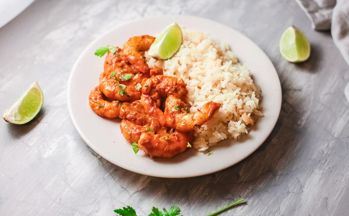 plate of Goan shrimp curry with rice and lime wedges