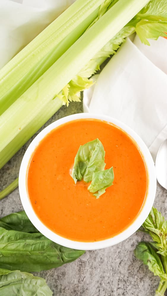 bowl of panera tomato soup next to celery 