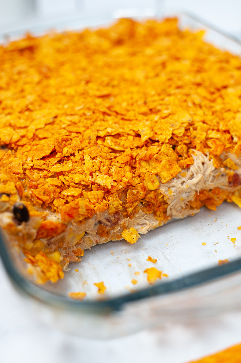 pan of dorito chicken casserole with a slice cut out
