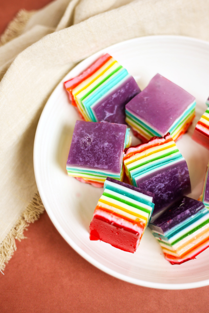 close up squares of rainbow layered jello on plate