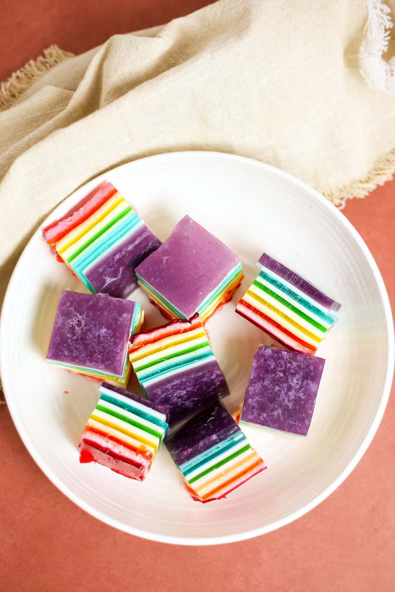 squares of rainbow layered jello on white plate
