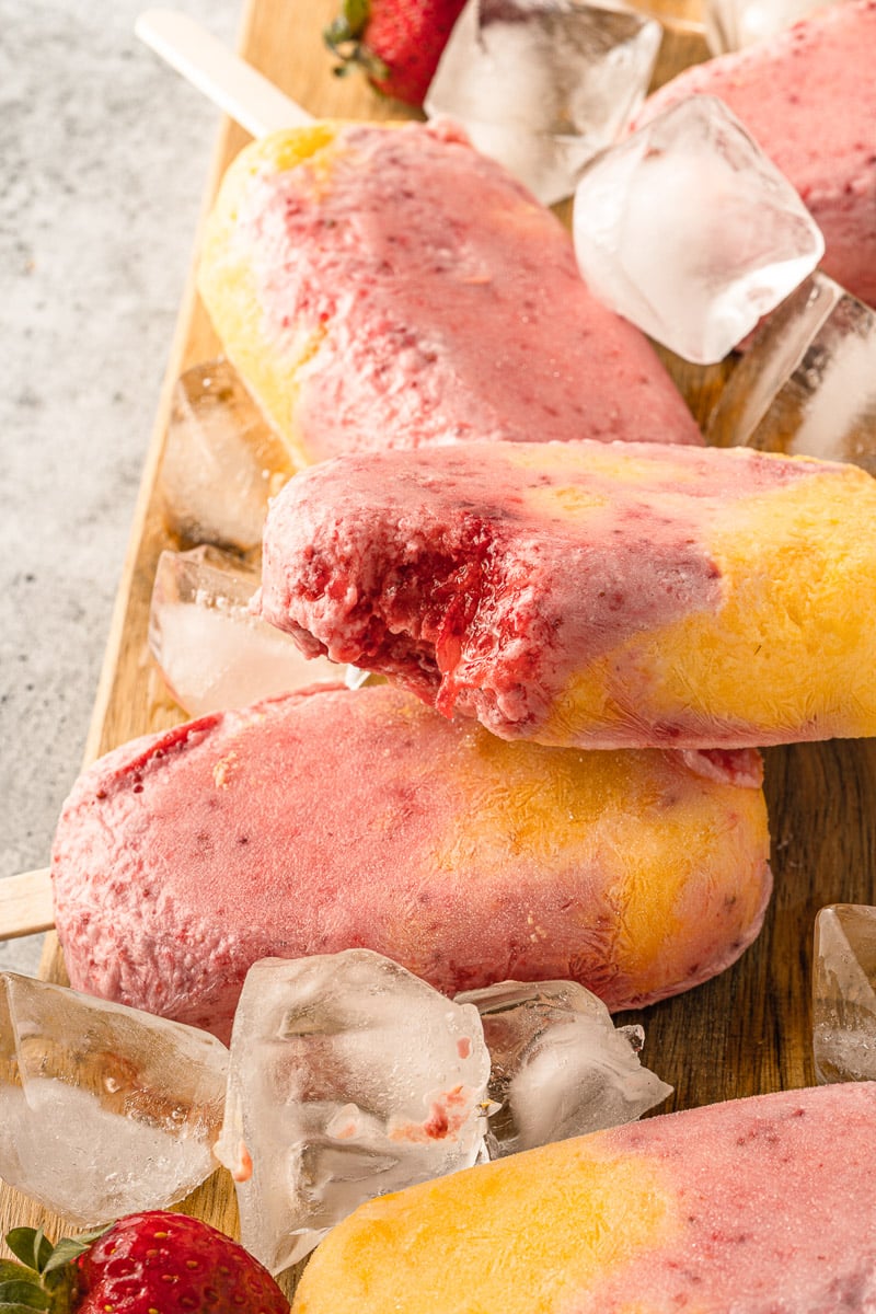 close up strawberry mango popsicles with bite take out
