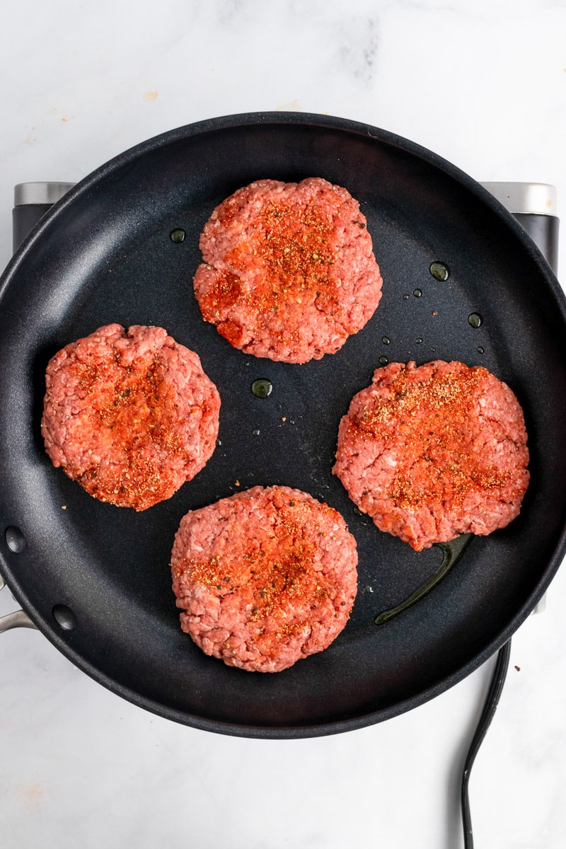 uncooked homemade burgers in skillet