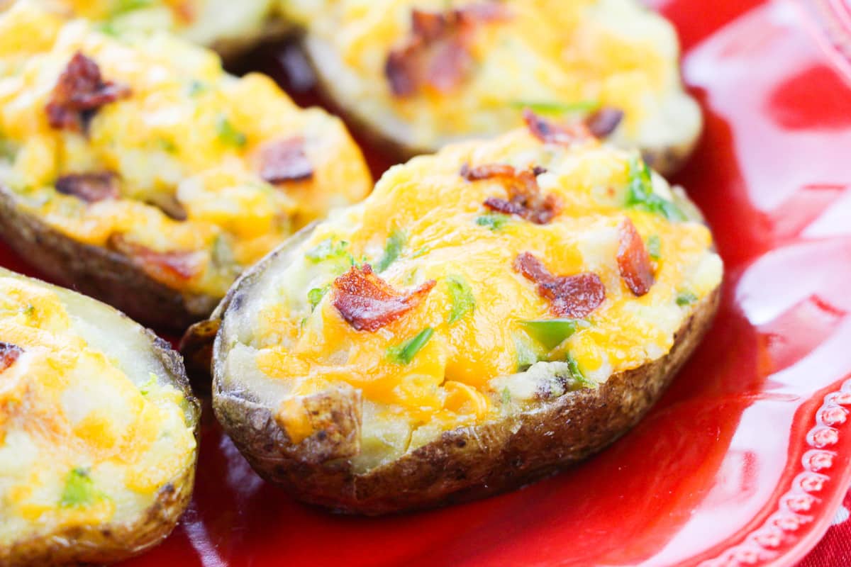 side view of loaded twice baked potatoes on red plate