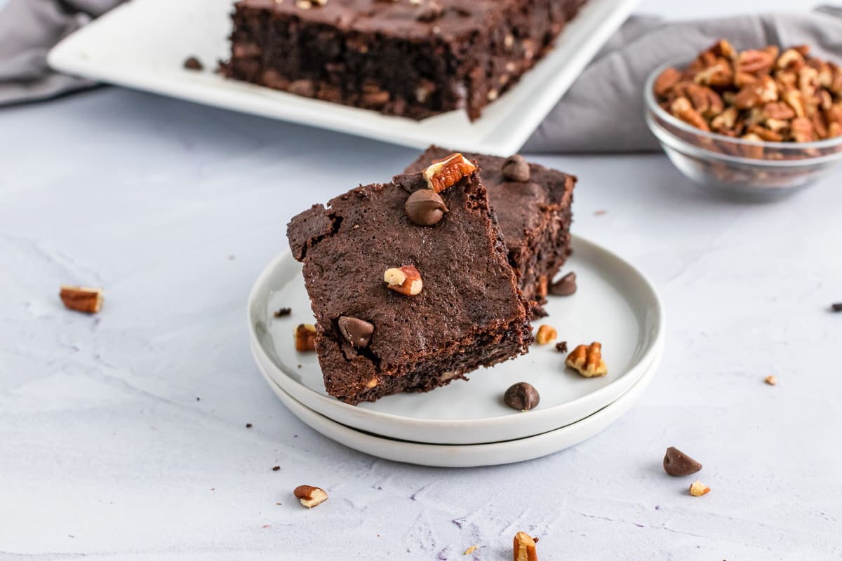 stack of pecan chocolate chip brownies on a small plate