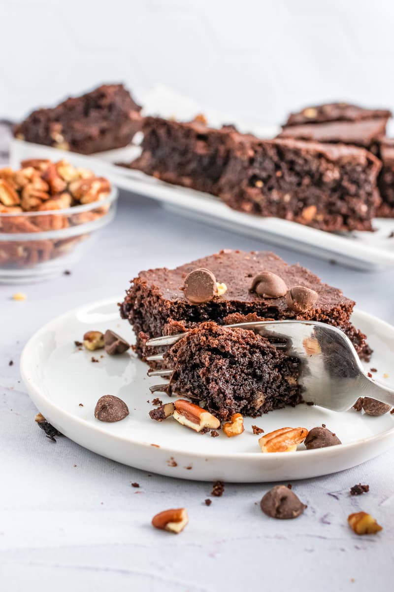 eating a piece of pecan chocolate chip brownies with fork