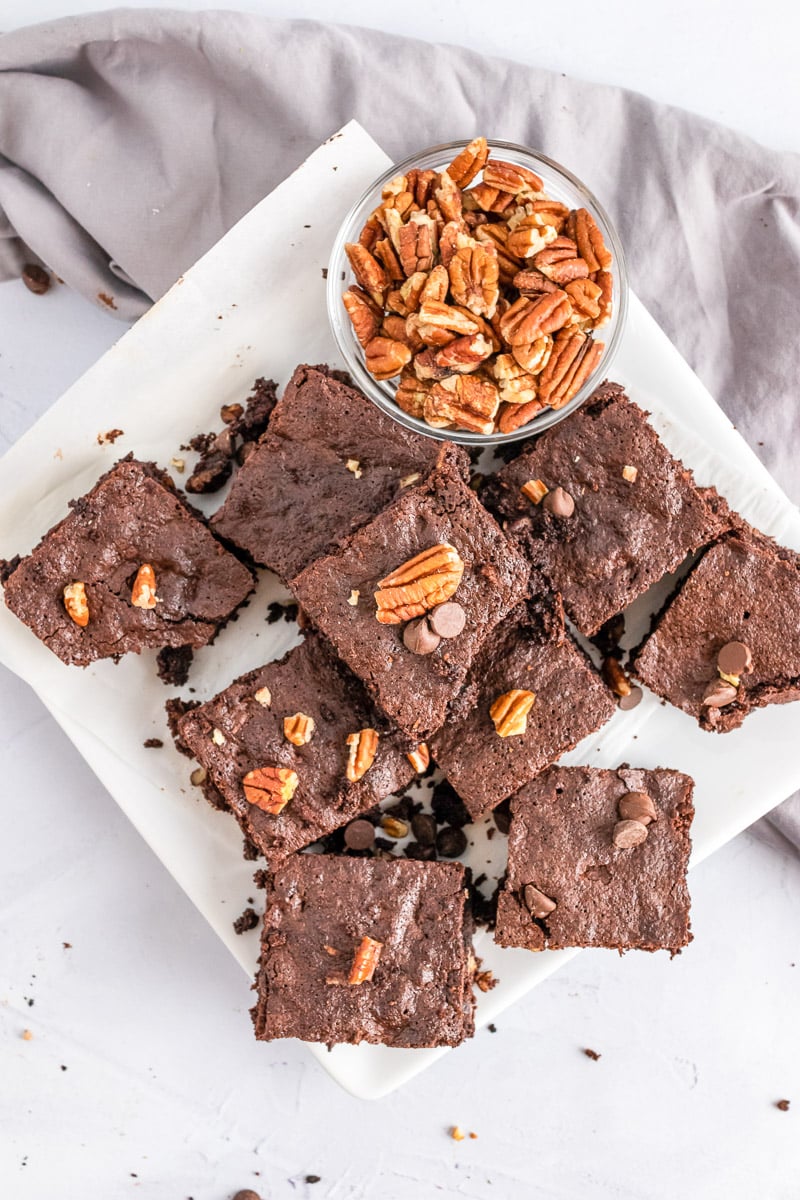 platter of pecan chocolate chip brownies with bowl of pecans