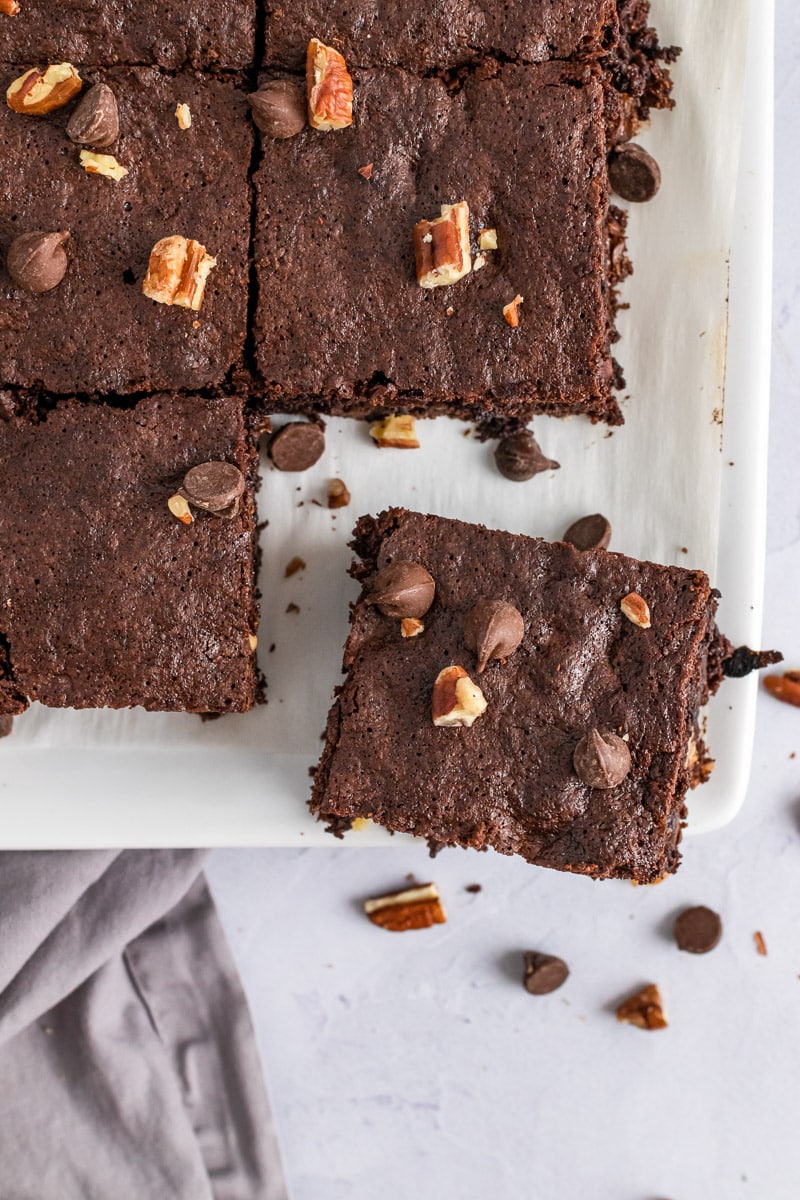 tray of pecan chocolate chip brownies with one piece coming out