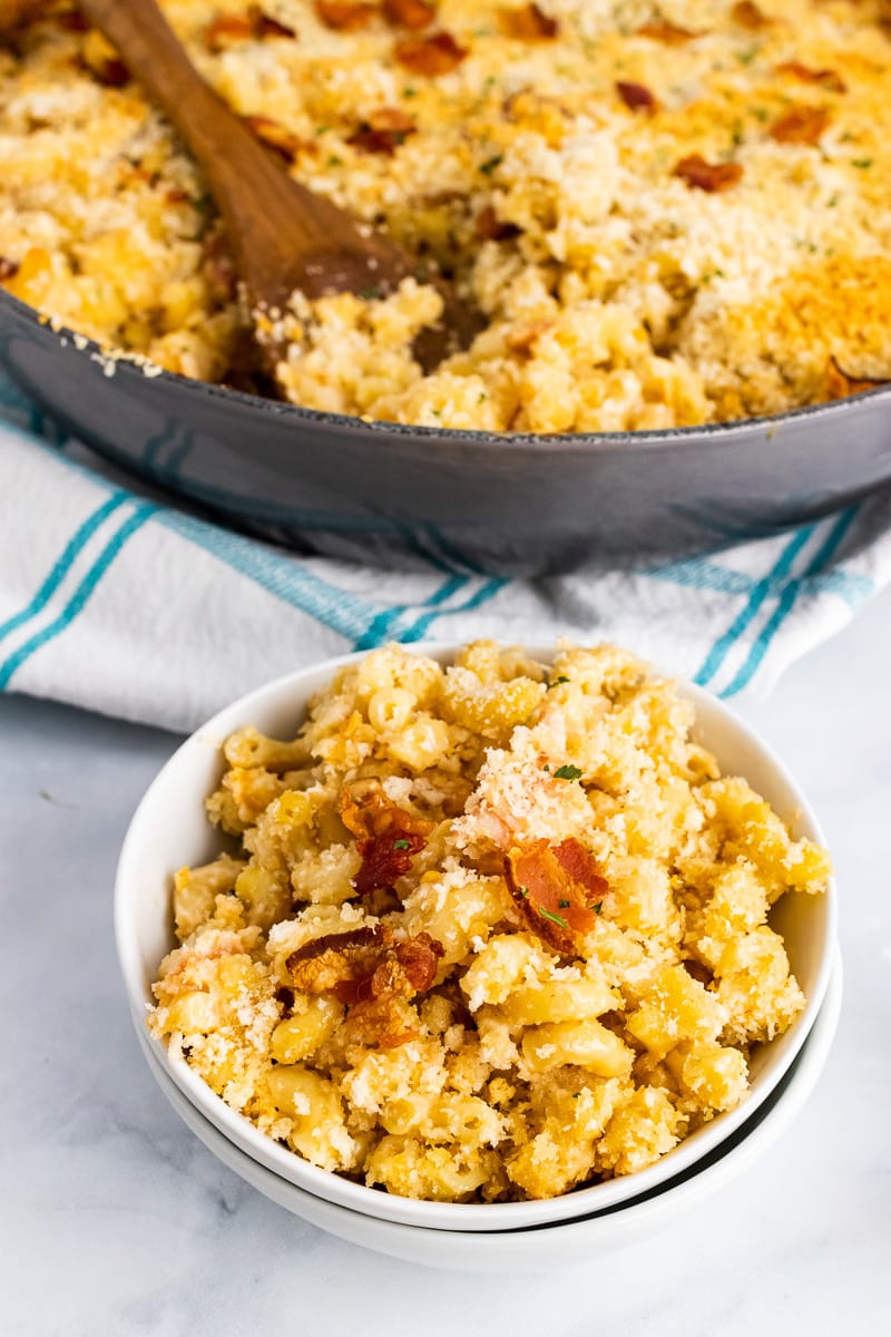 bowl of bacon mac and cheese in front of large pan full