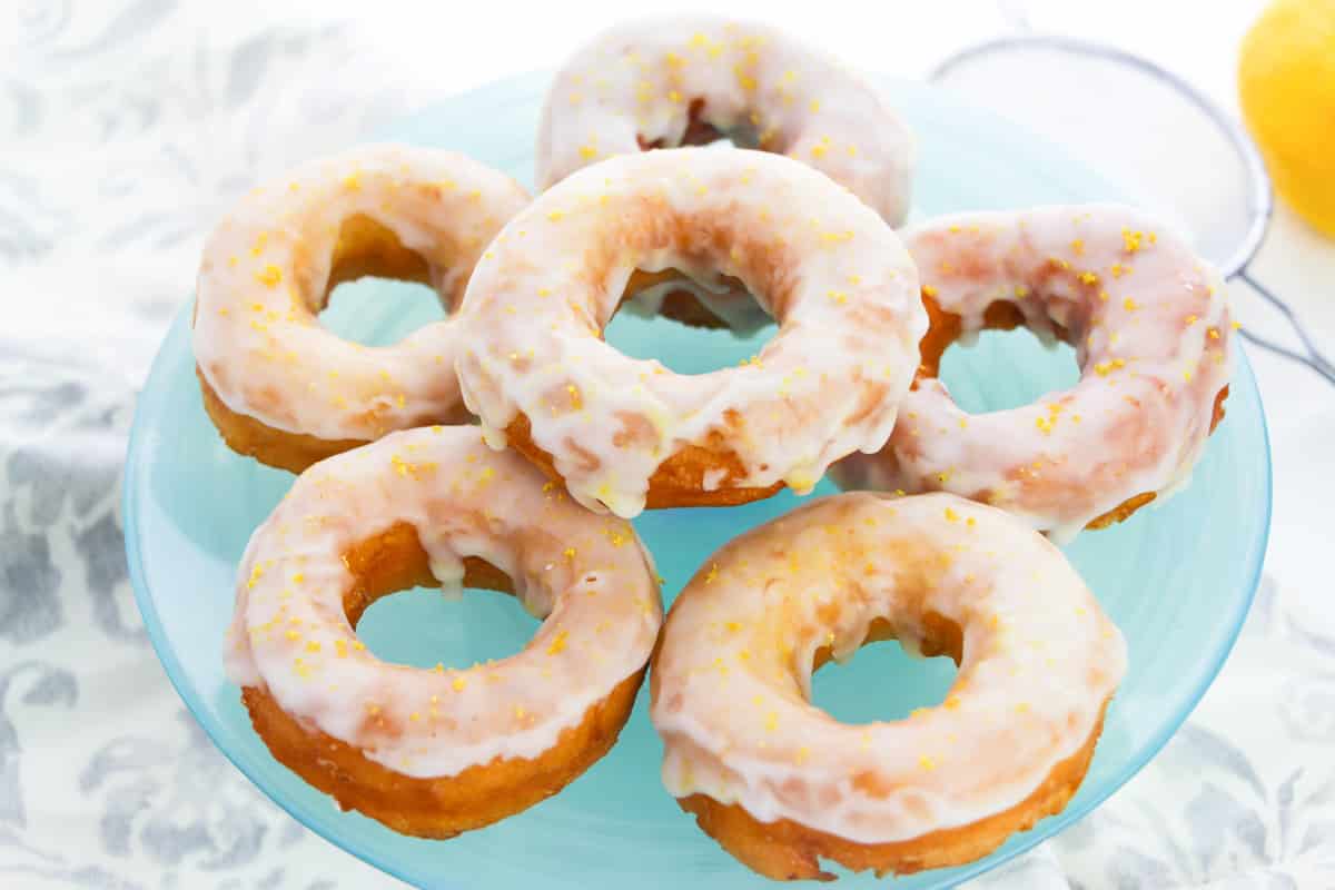 pile of glazed easy biscuit donuts on glass plate