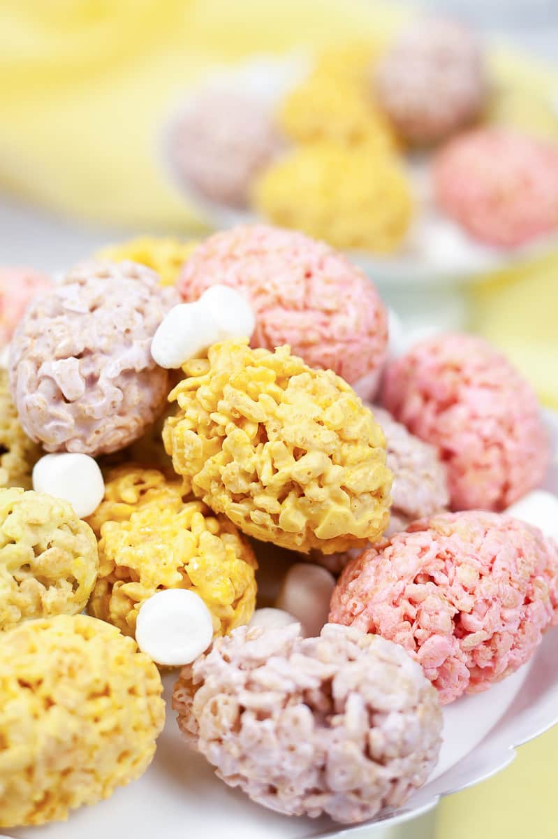 close up of easter rice krispie treats on white serving tray sprinkled with white mini marshmallows