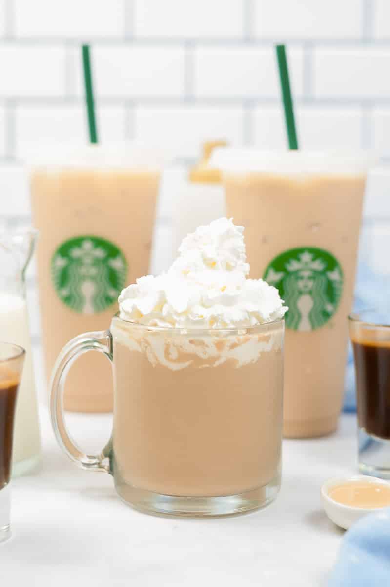 clear mug of copycat starbucks white chocolate mocha in front of two filled clear Starbucks tumblers
