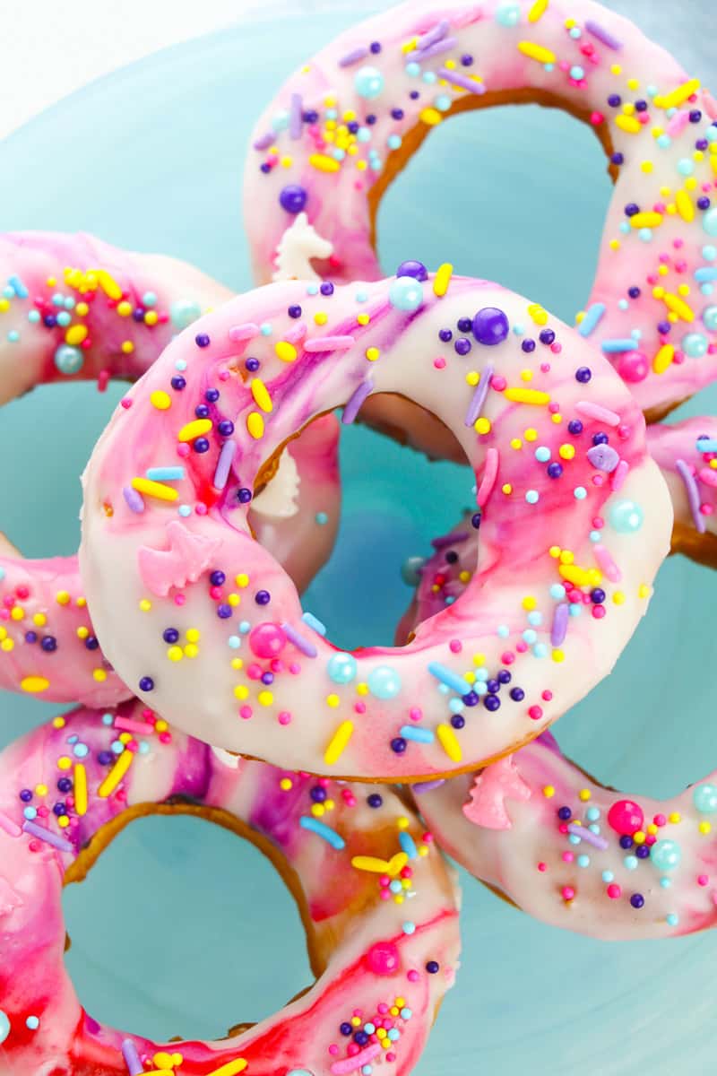 stack of unicorn donuts on blue background