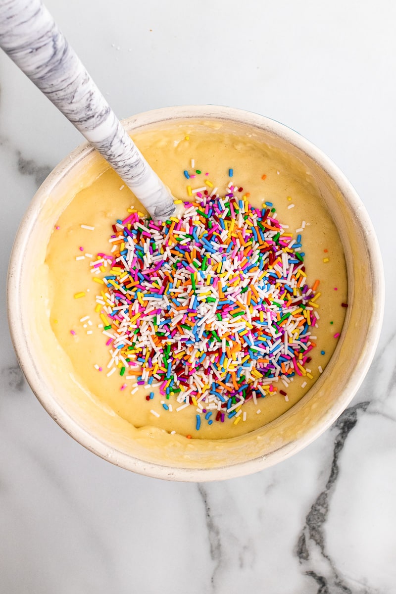 stirring sprinkles into batter for making funfetti pancakes