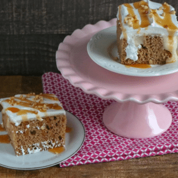 Apple spice poke cake slices topped with whipped topping, caramel and chopped nuts