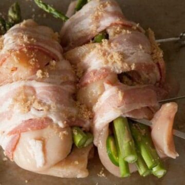 Chicken breasts stuffed with asparagus and jalapeño, wrapped in bacon and sprinkled with brown sugar on a skewer