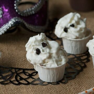Chocolate Halloween pudding shot topped with a whipped cream ghost and Oreo eyes