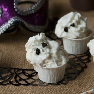 Halloween pudding shots topped with whipped cream ghosts with Oreo eyes