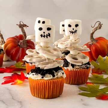 Halloween skeleton cupcakes with marshmallow skulls and candy-coated pretzel ribs