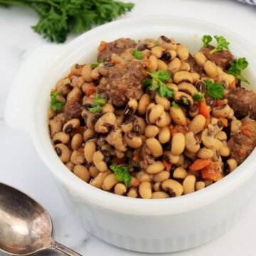 Slow cooker black eyed peas with beef stew meat and carrots in a white serving dish