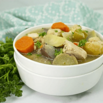 Slow cooker chicken stew with carrots, potatoes and celery in a white bowl