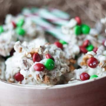 White chocolate pretzel clusters with red and green M&Ms in a wooden gift box